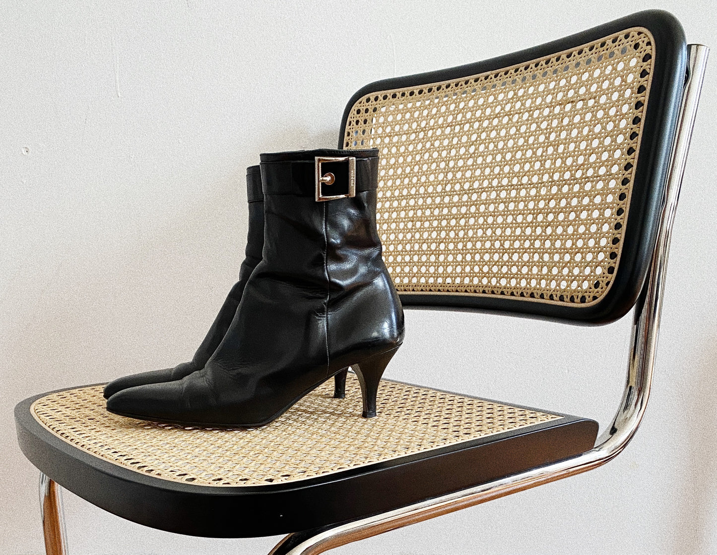 Black Prada boots featuring a buckle and pointy toe